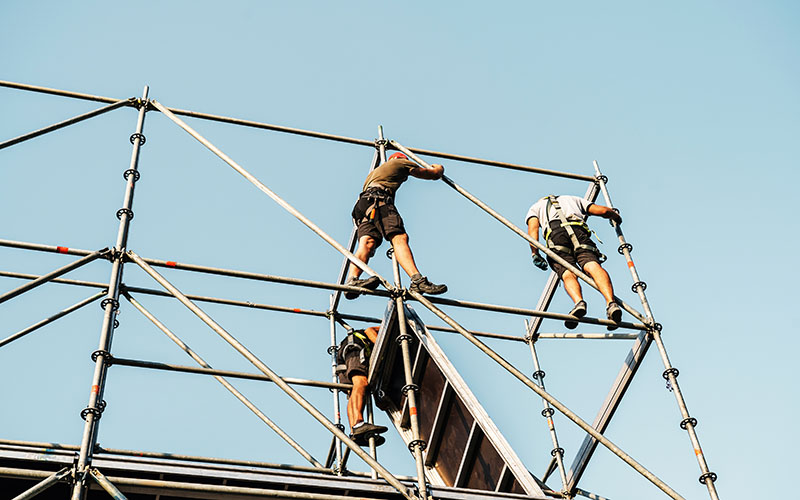 Builders mount a concert stage. Workers build a metal structure to install a mobile platform. Preparation for mass events and entertainment shows. unrecognizable person