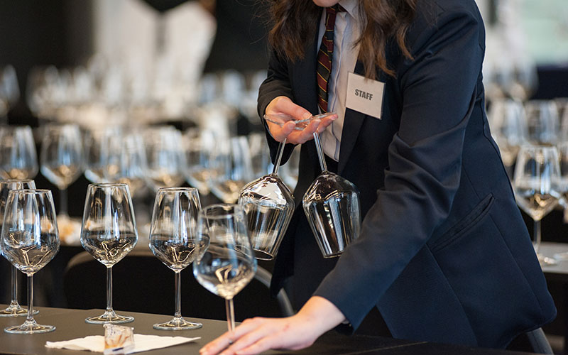 Waitress at work, preparing beverage for a wine tasting experience.